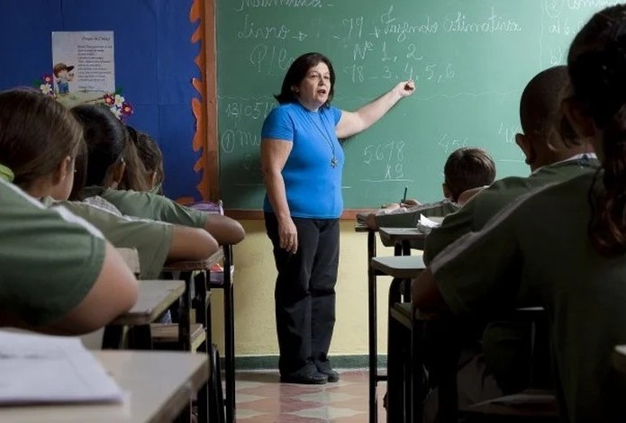 Professora em sala de aula do ensino fundamental em escola pública brasileira
